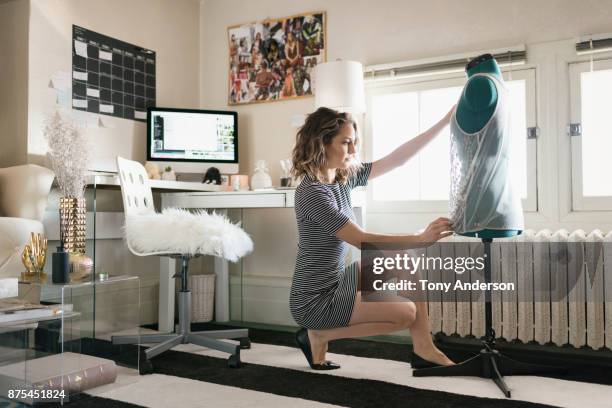 young woman fashion designer working in home studio - mannequin blonde stockfoto's en -beelden