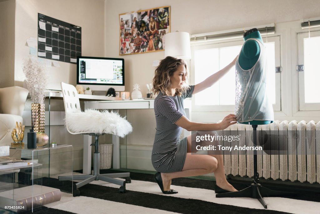 Young woman fashion designer working in home studio