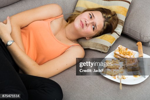 Girl is having a stomach ache after eating many cake Girl is having a stomach ache after eating many cake