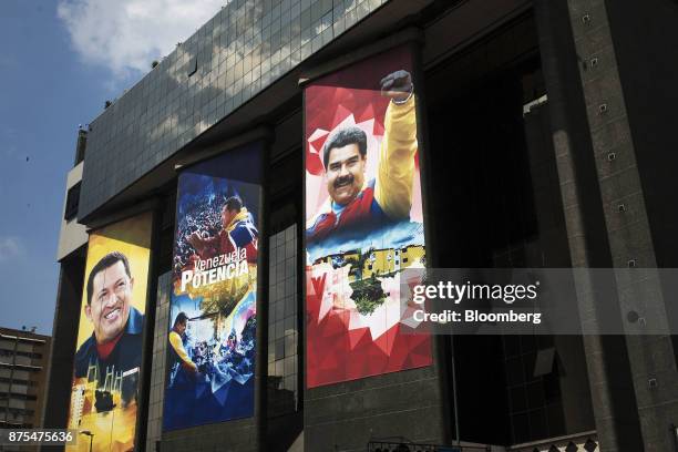 Banners featuring photographs of Nicolas Maduro, Venezuela's president, right, and former President Hugo Chavez, left, hang from the Ministry of...