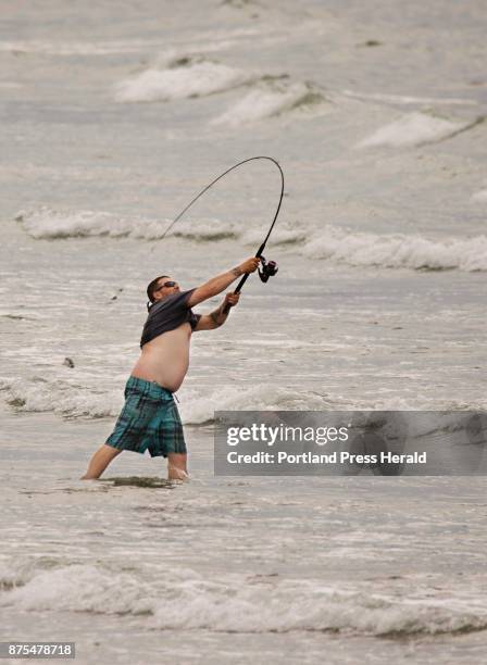 Tom Lawler of Windham casts in the surf while striper fishing at Higgins Beach in Scarborough on Friday, July 7, 2017.