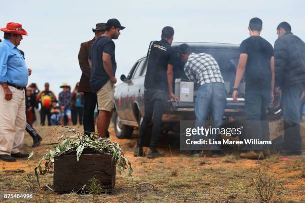 Aboriginal men carry the 40,000 year old remains of Mungo Man and ancestors from a hearse on their arrival to the Lake Mungo ceremony overlooking the...