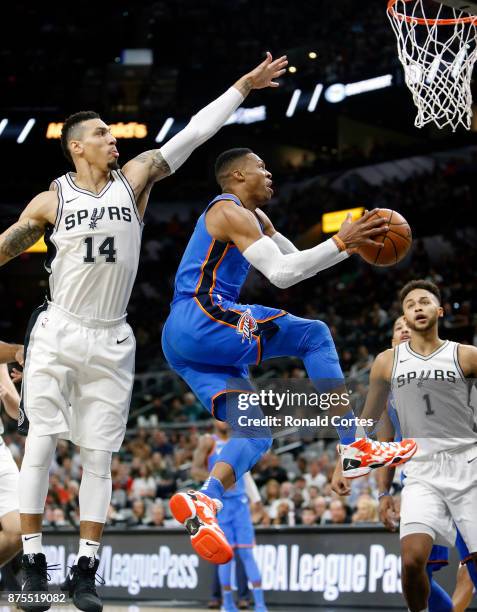 Russell Westbrook of the Oklahoma City Thunder drives under Danny Green of the San Antonio Spurs at AT&T Center on November 17, 2017 in San Antonio,...