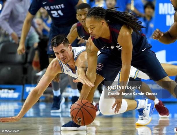 Donte Wright of the South Carolina State Bulldogs and Alex Olesinski of the UCLA Bruins battle for a loose ball in the first half of the game at...