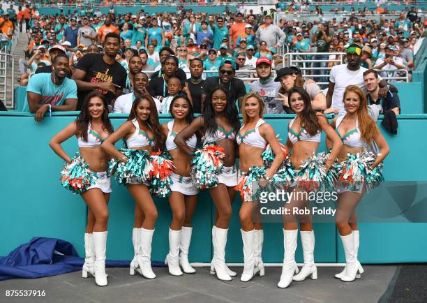 Miami Dolphins cheerleaders pose with members of the Miami Heat team during the game against the New York Jets at Hard Rock Stadium on October 22,...