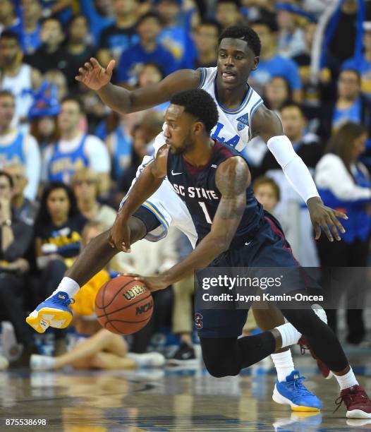 Aaron Holiday of the UCLA Bruins guards Justin Jones of the South Carolina State Bulldogs in the second half of the game at Pauley Pavilion on...