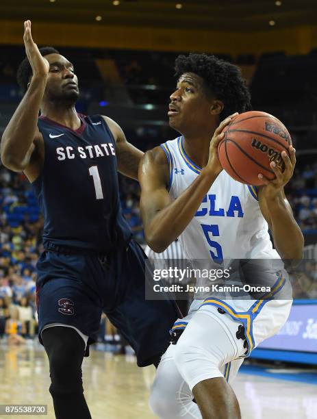 Justin Jones of the South Carolina State Bulldogs guards Chris Smith of the UCLA Bruins as he drives to the basket in the second half of the game at...