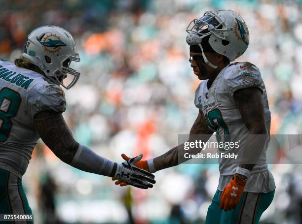 Kenny Stills of the Miami Dolphins slaps hands with Rey Maualuga during the game against the New York Jets at Hard Rock Stadium on October 22, 2017...
