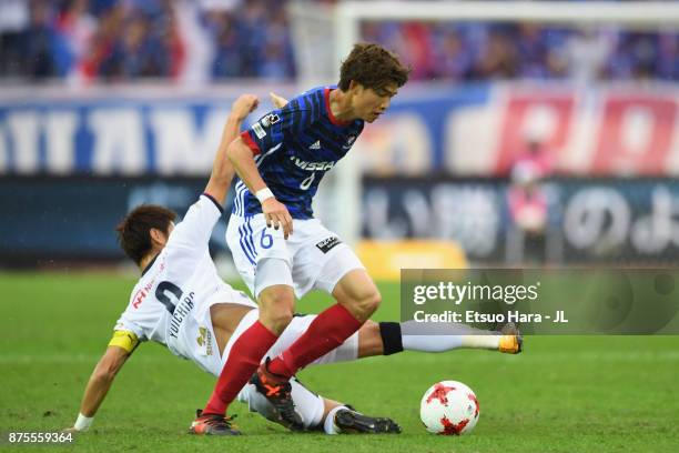 Takahiro Ogihara of Yokohama F.Marinos is tackled by Yoichiro Kakitani of Cerezo Osaka during the J.League J1 match between Yokohama F.Marinos and...