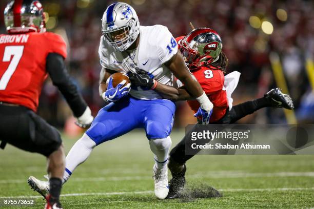 Running back Tavares Thomas of the Middle Tennessee Blue Raiders is tacked by Defensive Back Drell Greene of the Western Kentucky Hilltoppers at L.T....