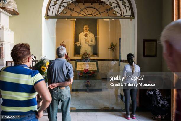 January 4, 2017: Believers stand in front of a painting of Dr. Jose Gregorio Hernandez who was a Venezuelan physician in the church of Nuestra Senora...