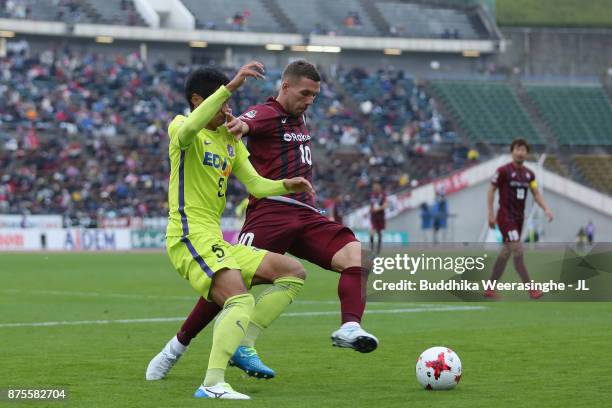 Lukas Podolski of Vissel Kobe and Kazuhiko Chiba of Sanfrecce Hiroshima compete for the ball during the J.League J1 match between Vissel Kobe and...