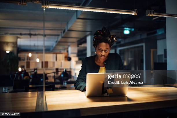 businesswoman working late on laptop - working overtime imagens e fotografias de stock