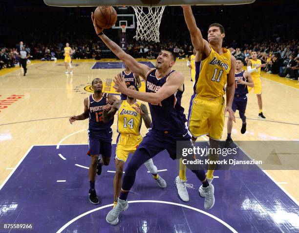 Alex Len of the Phoenix Suns scores basket against Brook Lopez of the Los Angeles Lakers during the second half of a basketball game at Staples...