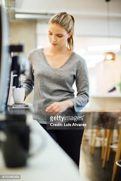 businesswoman using espresso maker at office - v neck stock pictures, royalty-free photos & images