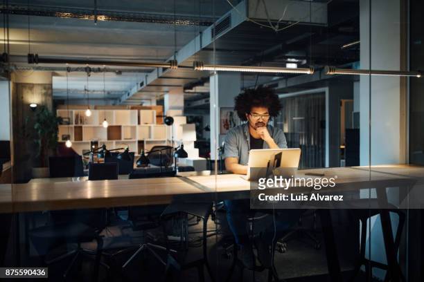 serious businessman working on laptop - working overtime imagens e fotografias de stock