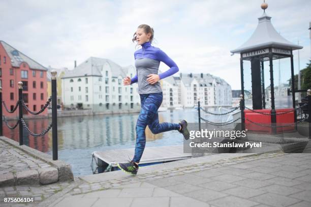 girl running along water canal , alesund city, norway - aalesund stock pictures, royalty-free photos & images