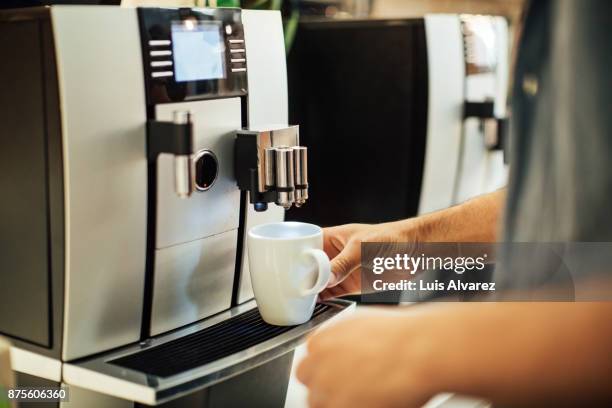 businessman using espresso maker - kaffeemaschine stock-fotos und bilder