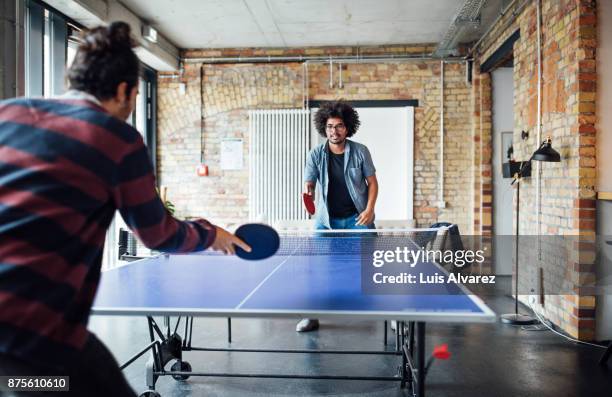 businessman playing table tennis with colleague - tischtennis stock-fotos und bilder