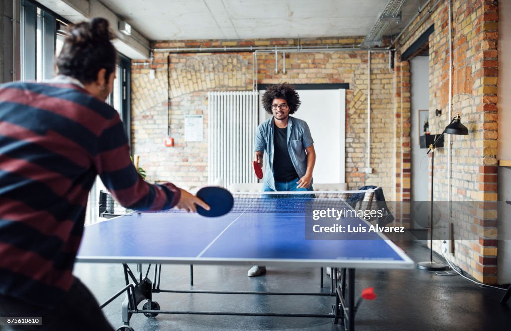 Businessman playing table tennis with colleague