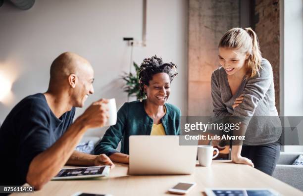 smiling business people looking at laptop in meeting - ethnische zugehörigkeit stock-fotos und bilder