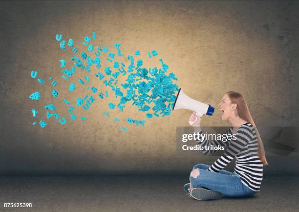 young woman screaming into megaphone - caucasian appearance photos stock pictures, royalty-free photos & images