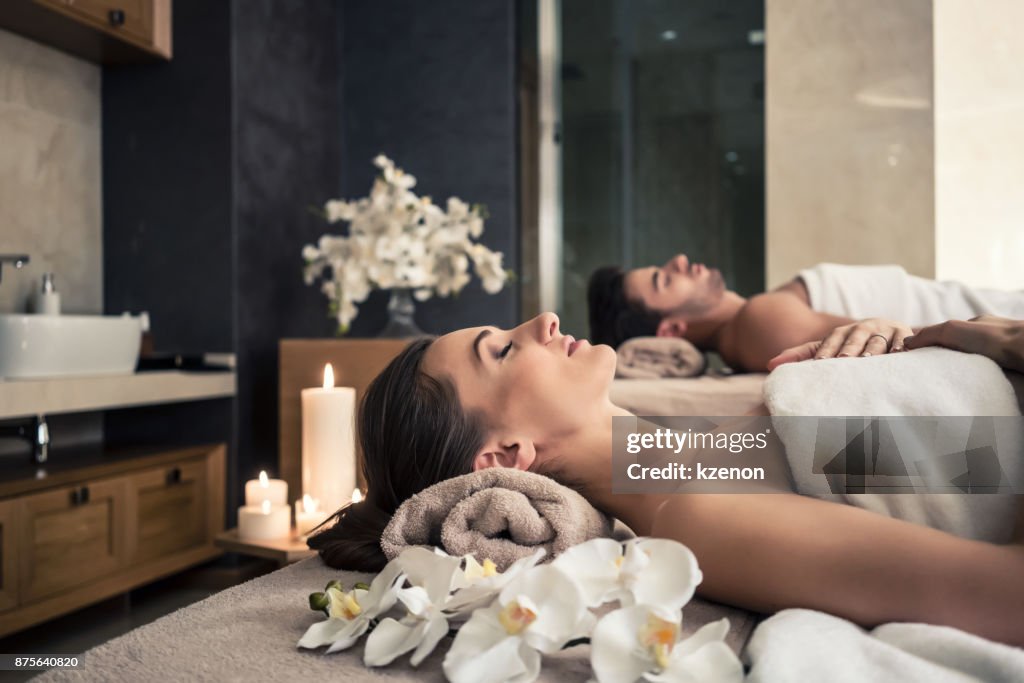 Man and woman lying down on massage beds at Asian wellness center