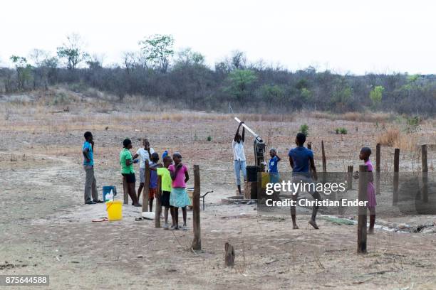 Zimbabwe, Banket A group of young people are trying to get some water out of a fountain and to fill it into a bucket.