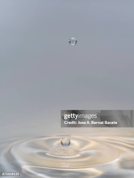 group of drops on line suspended in the air, falling down on a water surface that forms figures and abstract forms, on a gray background - onde sinusoïdale photos et images de collection