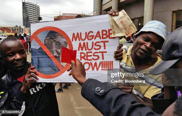 Demonstrators hold a placard reading "Mugabe Must Rest Now!" as they call for the resignation of president Robert Mugabe in Harare, Zimbabwe, on...