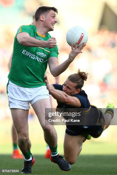 Conor Sweeney of Ireland looks to hand pass while being tackled by Nathan Fyfe of Australia during game two of the International Rules Series between...