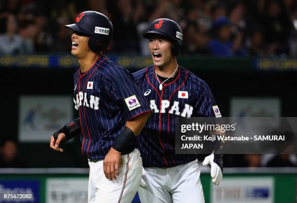 Infielder Shuta Tonosaki and Infielder Shogo Nakamura of Japan celebrate after scoring runs by a single of Infielder Yota Kyoda to make it 3-1 in the...