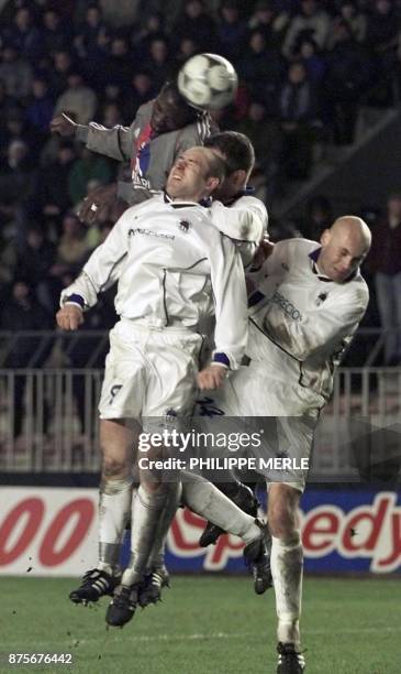 Le Lyonnais Marc Vivien Foe est à la lutte avec les Tchèques Stajner Jiri et Johana Petr , le 28 février 2002 au stade Letna de Prague, lors du match...