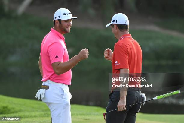 Justin Rose of England celebrates a birdie on the 16th green with Jon Rahm of Spain during the third round of the DP World Tour Championship at...