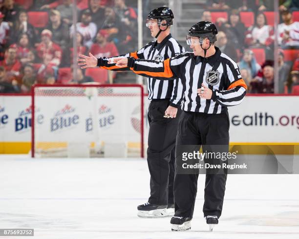 Referee's Kelly Sutherland and Kevin Pollock signal a good goal after a video review during an NHL game between the Detroit Red Wings and the Calgary...