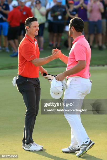 Jon Rahm of Spain shakes hands with Justin Rose of England on the 18th green during the third round of the DP World Tour Championship at Jumeirah...