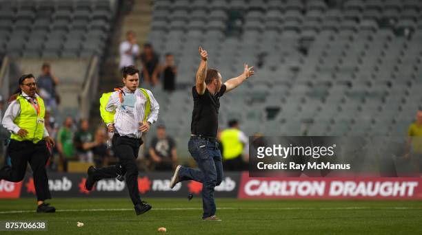 Perth , Australia - 18 November 2017; A man who ran on to the pitch after the game is pursued by security personnel after the Virgin Australia...