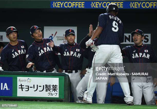 Outfielder Louis Okoye of Japan high fives with his team mates after scoring a run by the RBI double of Infielder Shuta Tonosaki to make it 8-0 in...