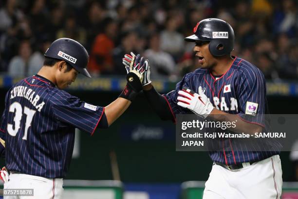 Outfielder Louis Okoye of Japan high fives with his team mate Outfielder Masayuki Kuwahara after scoring a run by the RBI double of Infielder Shuta...