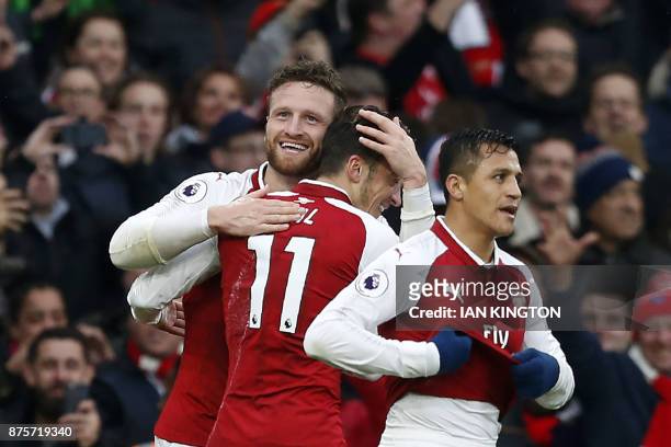 Arsenal's German defender Shkodran Mustafi celebrates scoring the team's first goal with Arsenal's Chilean striker Alexis Sanchez and Arsenal's...