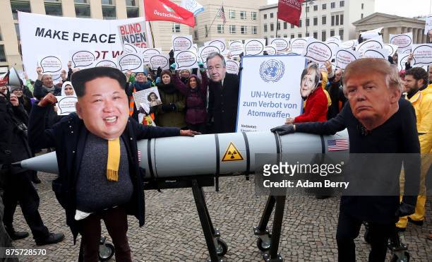 An activist with a mask of Kim Jong-un, chairman of the Workers' Party of Korea and supreme leader of North Korea , and another with a mask of U.S....