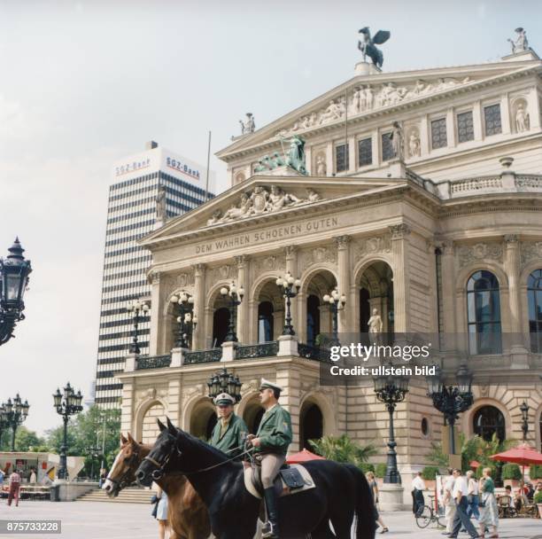 Vor dem Gebäude der Alten Oper in Frankfurt passieren zwei berittene Beamte der Polizei auf ihren Pferden den Vorplatz. Neben dem Operngebäude mit...