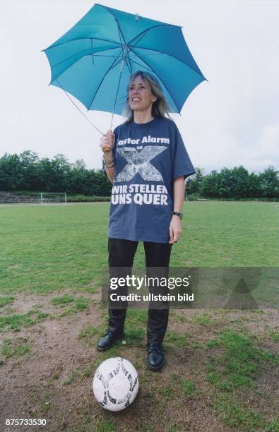 Gila Altmann, Politikerin von Bündnis 90/Die Gr�ünen, mit blauem Regenschirm und Fußball. Sie trägt ein T-Shirt mit einem Aufdruck gegen...