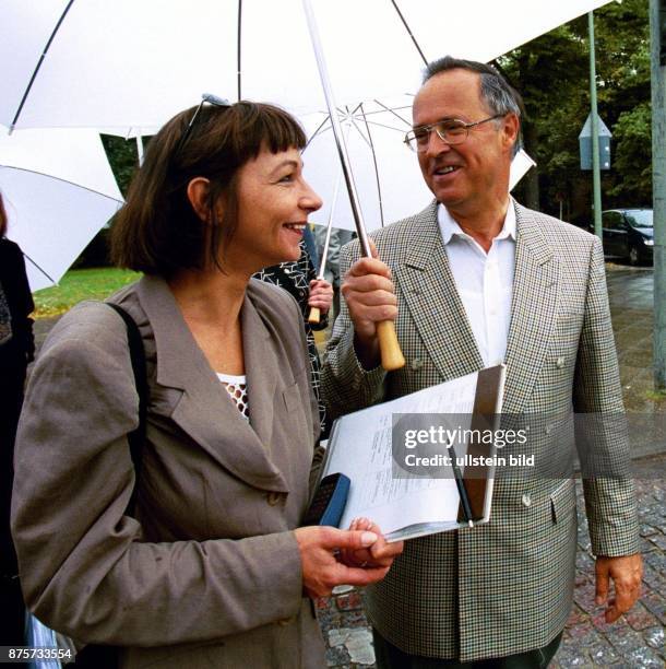 Bundesfinanzminister Hans Eichel mit seiner Pressesprecherin Maria Heider unterm Regenschirm. .