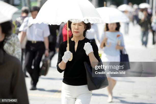 Japan, Osaka - Frauen mit Sonnenschirm, die helle Haut behalten wollen