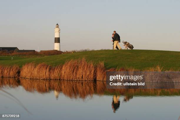 Golfer auf dem Golfplatz von Kampen. Im Hintergrund der Leuchtturm von Kampen auf Sylt