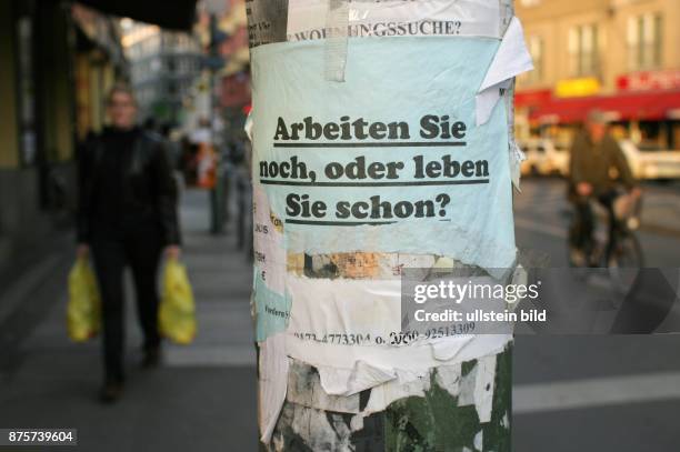 Plakat mit dem Slogan "Arbeiten Sie noch, oder leben Sie schon?" an einer Ampel am Hackeschen Markt in Berlin - Mitte. Eine Abwandlung des...