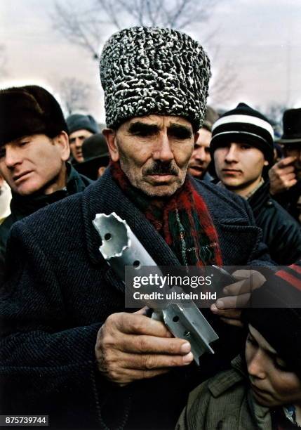 Tschetschene mit Pelzmütze zeigt Teile russischer Granaten in Grosny - Januar 1995