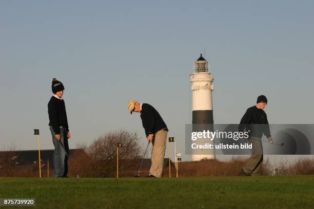 Jugendliche auf dem Golfplatz von Kampen. Im Hintergrund der Leuchtturm von Kampen auf Sylt