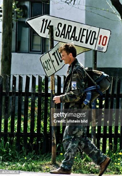 Ein bosnischer Soldat läuft an einem Wegweiser für Sarajewo und Tuzla vorbei. Dezember 1995